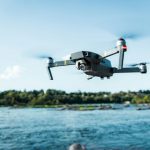 Drone - black DJI Mavi quadcopter near body of water