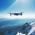 Drone - white quadcopter drone flying near snow mountain during daytime