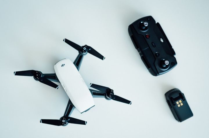 Drone - white and black quadcopter drone on white table