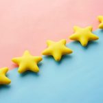 Review - a row of yellow stars sitting on top of a blue and pink surface