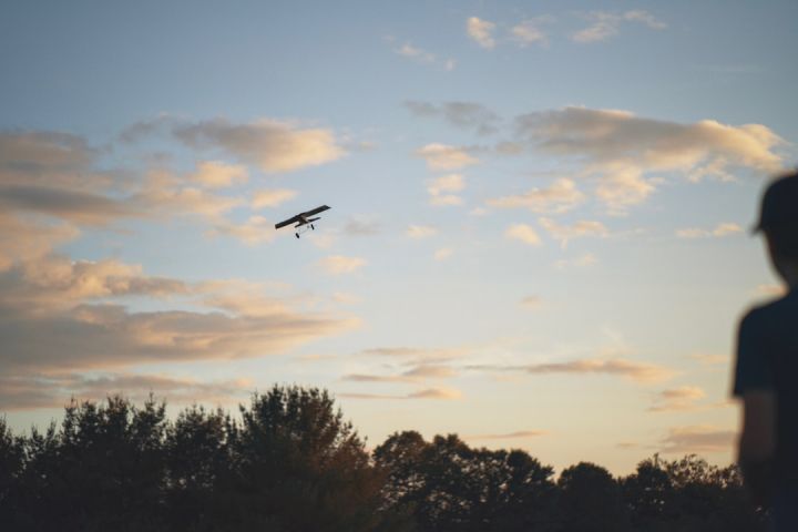 Remote Control Planes - a person looking at a plane flying in the sky