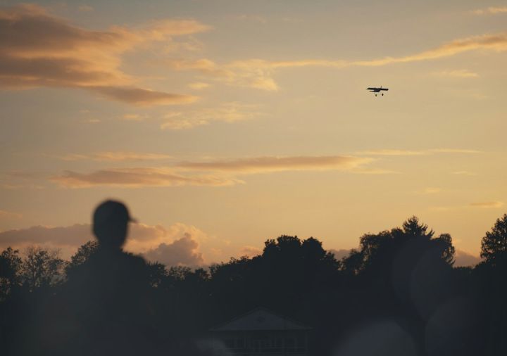 Remote Control Planes - a plane is flying in the sky at sunset