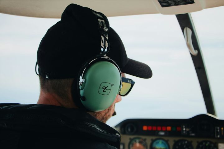 Radio-Controlled - man wearing black top and black baseball cap using green headset