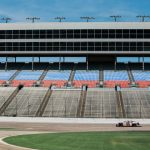 Fpv Racing - aerial photography of car on stadium under clear blue sky