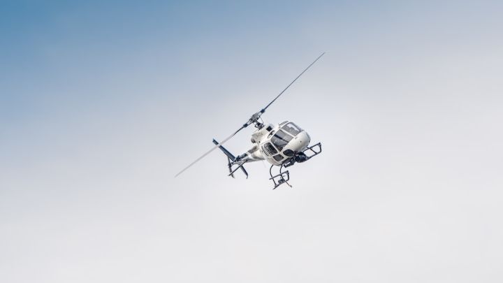 Helicopter - white and black drone flying under blue sky during daytime