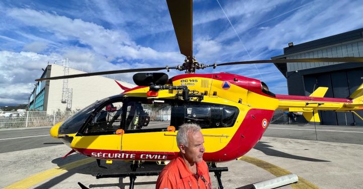 Rotors - Pilot in Front of a Civil Security Helicopter Standing on a Helipad